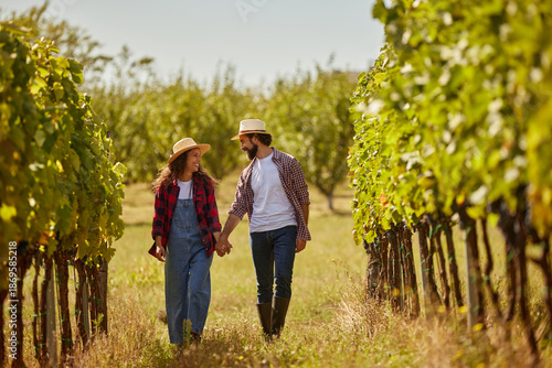 Bilde på lerret A couple strolls through a lush vineyard, enjoying the warm sun as they share moments together while managing their family wine production