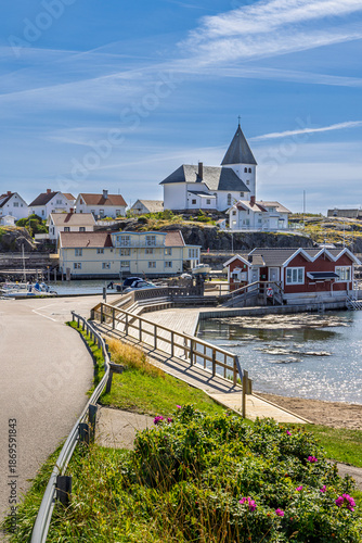 фотографія Scenic coastal village on Tjorn, Sweden with white church on hill, harbor and bo
