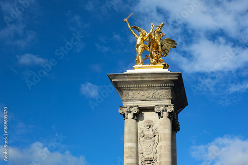 One of the famous gilded Fames restraining Pegasus sculptures on its massive stone socle at the entrance of the 1900 Alexandre III bridge, Paris, France