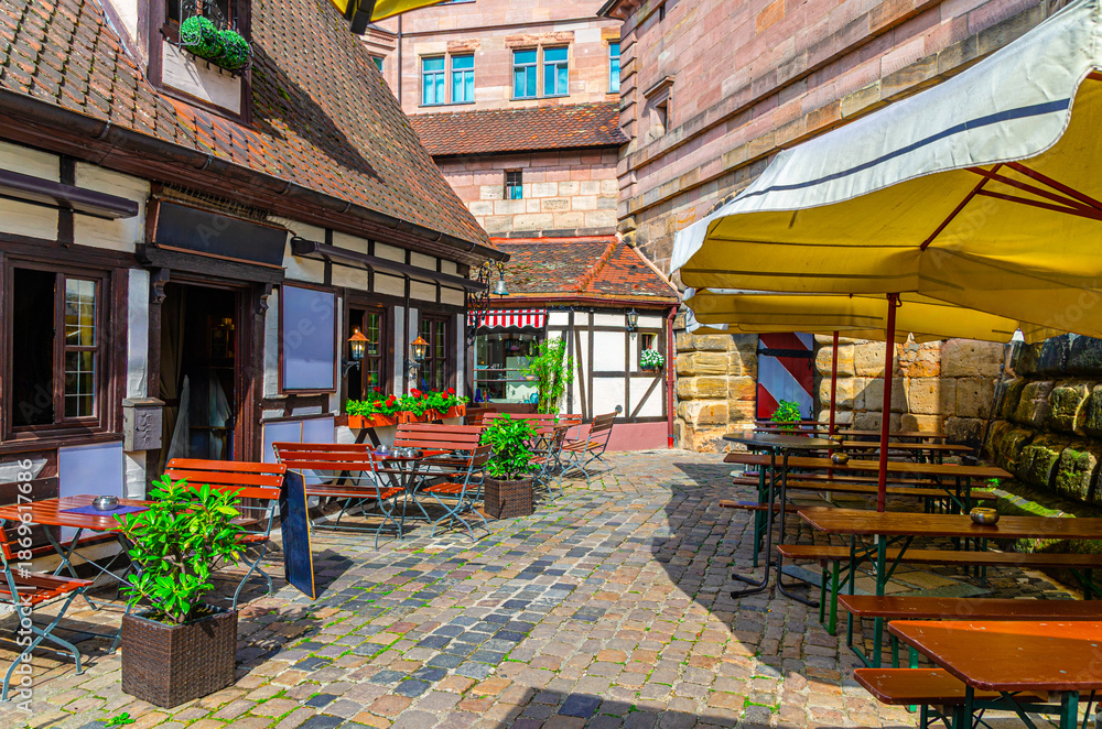 Obraz premium Old town Nuremberg city historical center Craftsmen's Courtyard with traditional half-timbered houses, typical colorful buildings, street restaurants and outdoor cafes, Bavaria state, Germany
