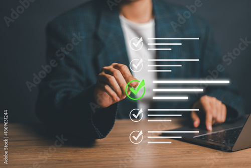 Businessperson using a digital checklist on a laptop, symbolizing productivity and task management in a modern office environment.