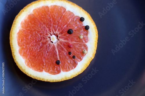 Grapefruit with black pepper on a black background