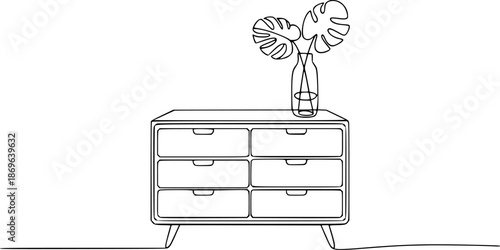 Minimalist of a dresser with monstera leaves in a glass vase furniture plant