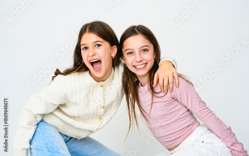 Two cute and Young pre teen girl on studio white