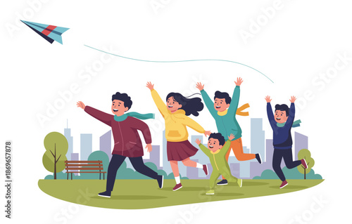 Family running and flying paper airplane in city park