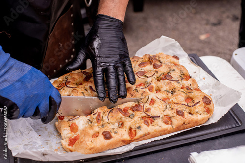 Male hands of a cook cutting bruschetta bread