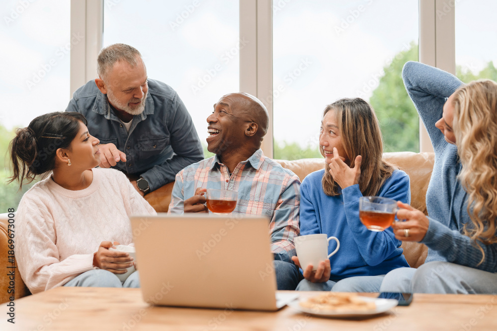 Fototapeta premium Friends enjoying drinks and snacks together indoors during a sunny afternoon