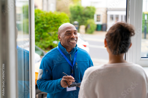 Schilderij op canvas Man at the door smiles while talking to a woman during daytime visit