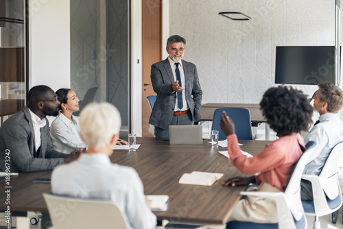 Senior business leader leading diverse corporate team meeting