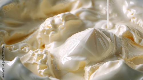 A commercial-style video with close-up shots showing banana ice cream in a bowl with condensed white milk poured over it, emphasizing the natural texture, shimmering details, and fluid movement