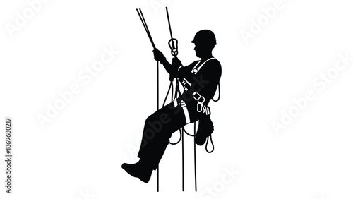 Silhouette of a worker rappelling down from a height using ropes and harness