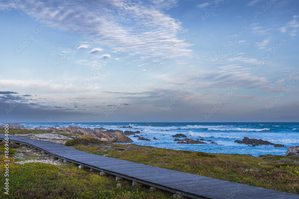Obraz premium Meeting point of Atlantic and Indian Ocean in Cape Agulhas, South Africa. Garden Route