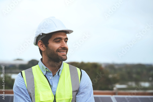 Фотография engineer wearing a yellow vest and a white hat is smiling