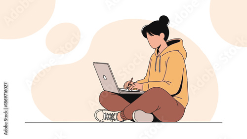 Young woman in casual clothes working on a laptop, sitting cross-legged on the floor