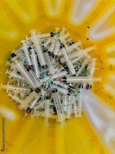 Used syringes inside medical disposal container
