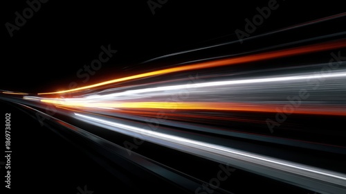 Vehicles move quickly along the road leaving bright trails of light against the dark background. The scene captures the speed and motion of night travel.