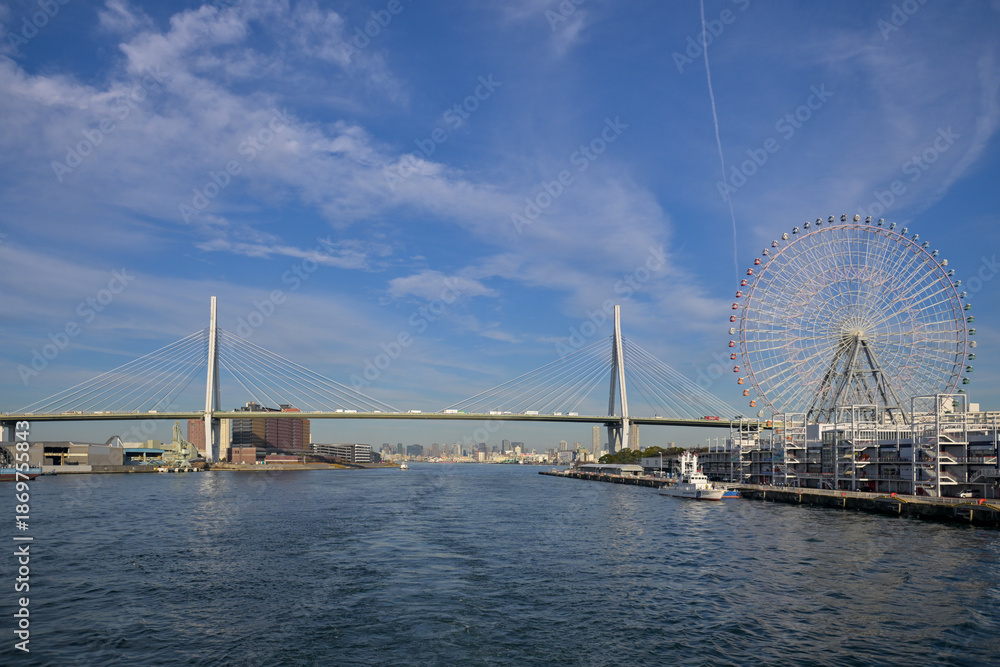 Obraz premium Sailing Through Osaka Bay with Bridges and Ferris Wheel