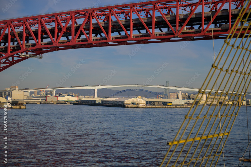 Obraz premium Sailing Through Osaka Bay with Bridges