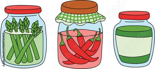 Set of glass jars with preserved vegetables, pickled green asparagus, and red chili peppers for kitchen pantry storage