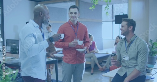 Chatting three men wearing shirts holding coffee cups and travel mug in open office with lanyards