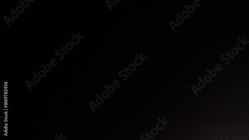 左から右、右から左へ、ざらざらした壁面を照らすサーチライト(ループ素材)