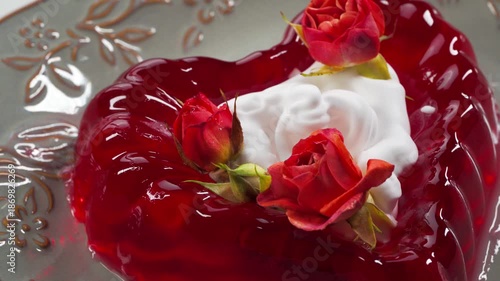 Close up of Red heart-shaped Jelly Dessert with Roses and whipped cream. Tracking shot