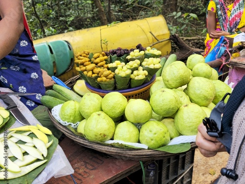 Local street fruit stall displaying fresh amla, guava, groundnuts, and sliced mango, representing Indian roadside market culture.