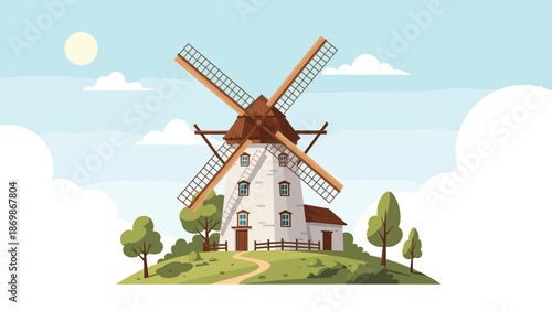 Traditional stone windmill standing on a green grassy hill under a bright sunny sky with fluffy white summer clouds.