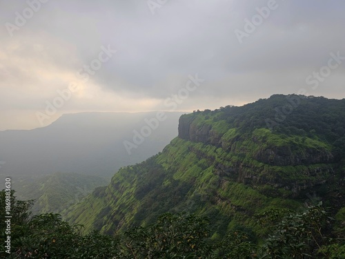 Wide view of green hills and valleys under cloudy skies in Matheran, capturing a serene monsoon atmosphere in the Western Ghats.