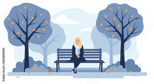 Lonely young woman sitting on a wooden park bench in a quiet forest with falling leaves and soft blue tones suggesting winter or autumn.