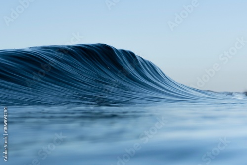 Fotografie Minimalist ocean wave with smooth blue water and clean lines, showcasing the nat