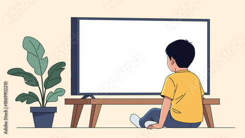 Young boy sitting on the floor and watching a large blank flat screen television in a living room with a plant.