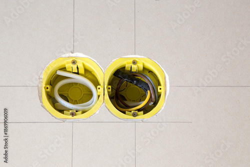 Two yellow electrical sockets installed in drywall