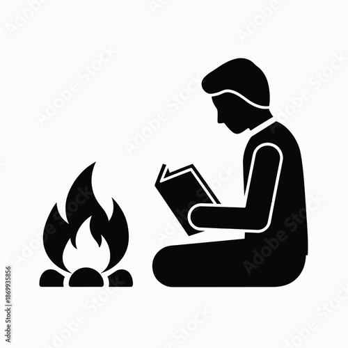 Person reading by campfire