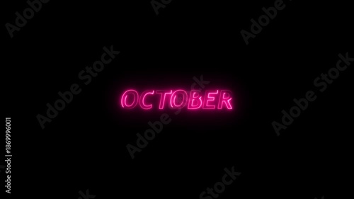 Bright pink neon sign spelling out the word OCTOBER glowing intensely against a completely black background with a subtle light halo effect around the letters Keywords: October