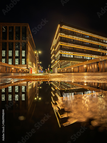 The Beam in Sunderland illuminated at night and reflected in a  puddle