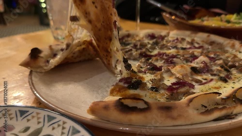 Mushroom pizza, take a slice at night in a restaurant late in the evening