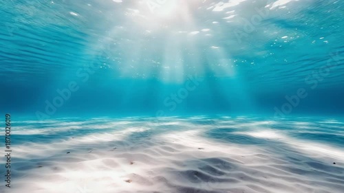 Sunlight filtering through ocean water to sandy seabed - 4k video