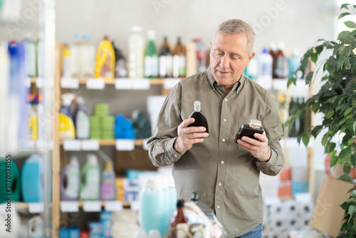 Senior man sniffs fragrance of perfume, choose scent spray with pleasant smell. Customer pulverize perfume, chooses toilet water. Client sprays perfume, snuff it and chooses perfume