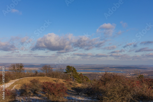 Winter Palava landscape view of Nove Mlyny reservoirs and red hawthorn. South Moravia, Czechia under blue sky with light snow