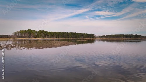 Aerial shot over calm Chickahominy River with marshland and horizon glow, Virginia