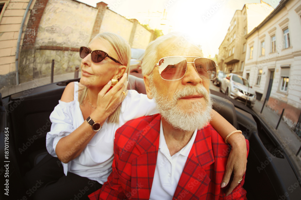 © New Africa - Stylish elderly couple enjoying ride in convertible car, wide angle lens