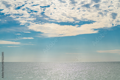 Sea with calm summer sky background. Sea in summer daylight. Sea calm with sunlight. Sea smooth and bright.