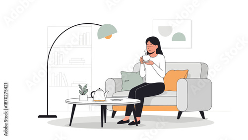 Woman sitting on sofa drinking tea peacefully.