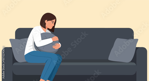 A woman sits on a sofa, clutching a pillow, conveying feelings of sadness or loneliness