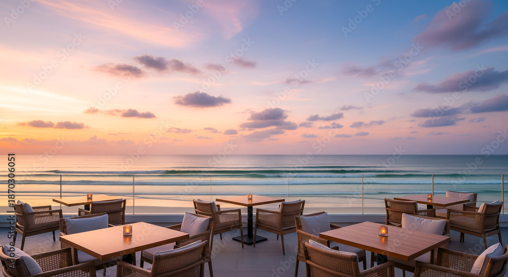 Obraz premium Elegant seaside restaurant terrace overlooking the ocean during golden sunset, featuring modern furniture and refined table settings, perfect for luxury travel, vacation, and fine dining visuals