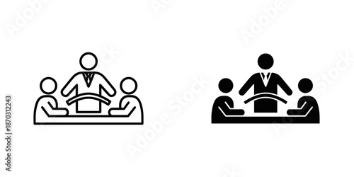 Black and white of people sitting at a table with a person standing