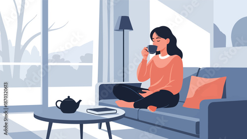 Woman enjoying a warm drink while relaxing on a comfortable sofa.