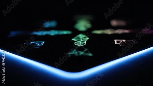 Close up on a futuristic gaming mousepad displaying vibrant abstract neon light patterns and a bright glowing blue border against a completely dark background emphasizing technology