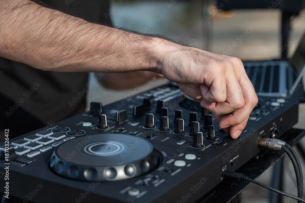 Obraz premium Close up of DJ's hands while working outdoors. 